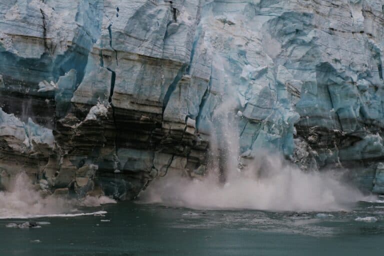 A large glacier with water pouring out of it